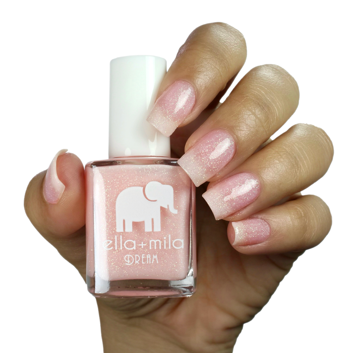 Relevé translucent pink shimmer nail polish on a medium skin tone, hand holding the bottle