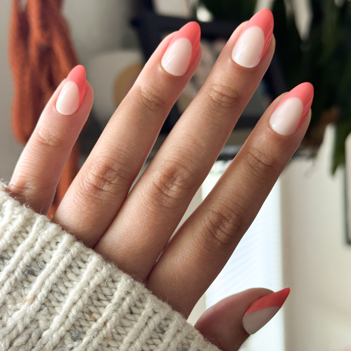 Ride Into The Sunset French - Press-On | Medium | Almond featuring sheer neutral nails with bright coral tips for easy at-home mani
