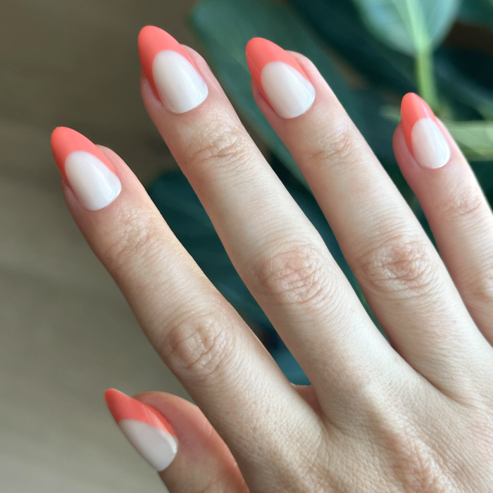 Ride Into The Sunset French - Press-On | Medium | Almond featuring sheer neutral nails with bright coral tips for easy at-home mani