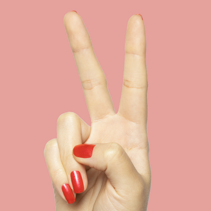 Hand showing peace sign with bright pinky-red Rodeo Queen polish with silver shimmer for a mani