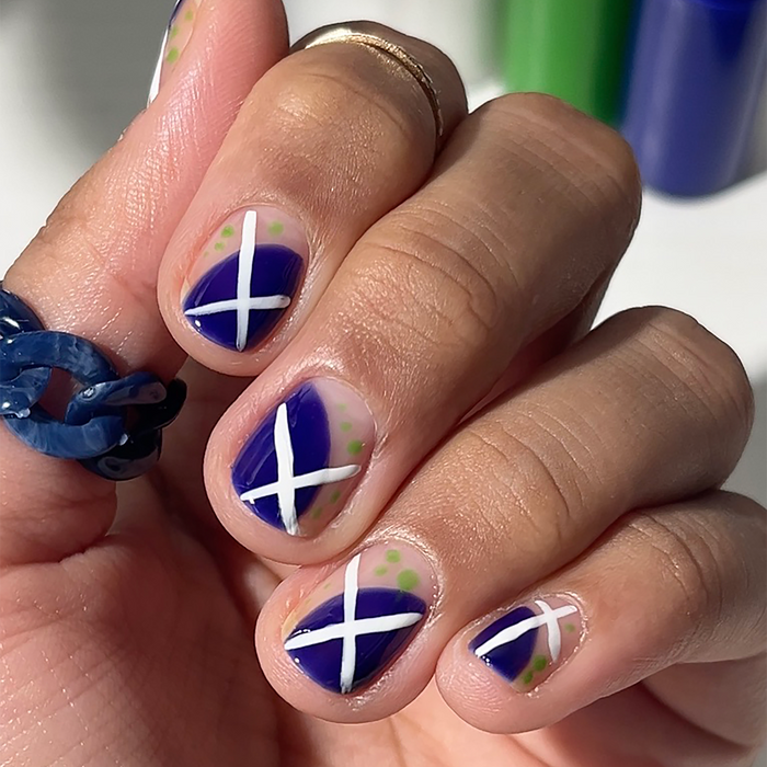 Royal Blue liner used for blue and white X nail art on a medium skin tone, holding the bottles