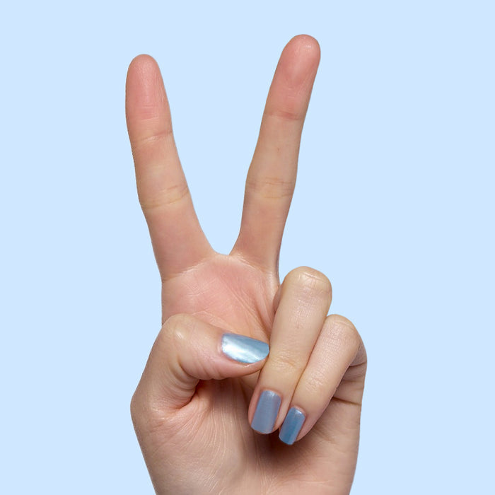 Same Day Next Year shiny sheer blue polish on short nails with a smooth finish for an easy at-home manicure