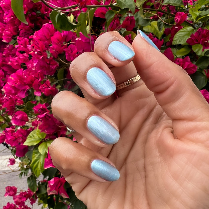 Same Day Next Year sheer shimmery blue polish on short nails with a smooth glossy finish for an easy at-home mani