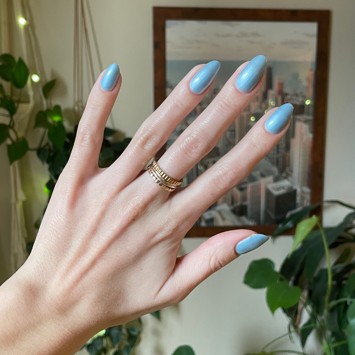 Same Day Next Year sheer blue polish on medium-length nails with a smooth, glossy finish for an easy at-home manicure