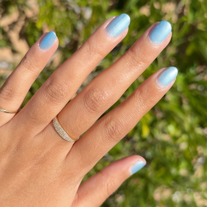 Same Day Next Year sheer shimmery blue polish on natural nails with a smooth finish for an easy at-home manicure