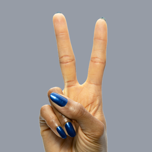 Hand showing peace sign with nails painted in Sapphire Season gel polish featuring deep blue chrome manicure