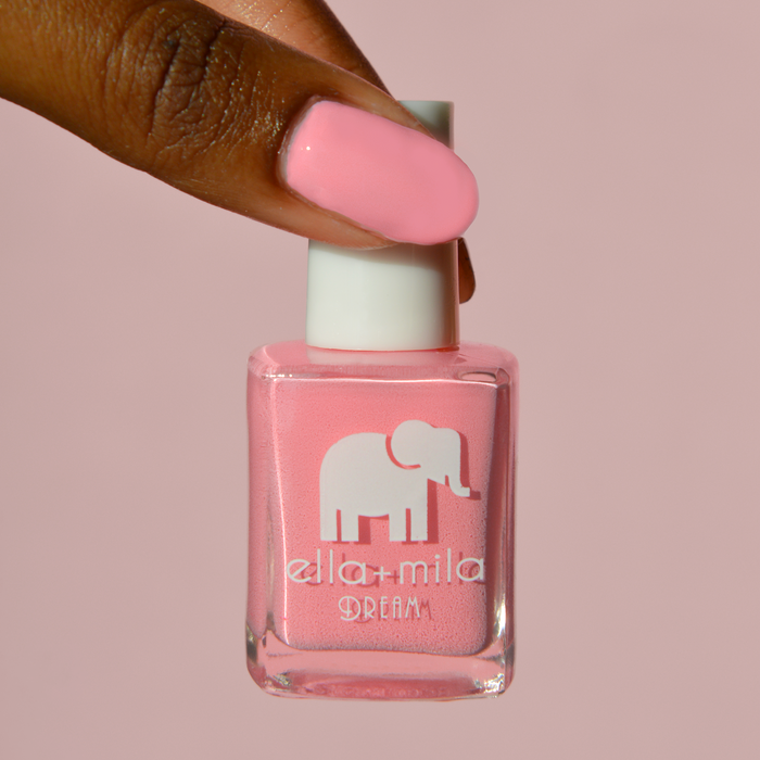 Set the Barre High rosy pink nail polish on a deep skin tone, holding the bottle on a pink background