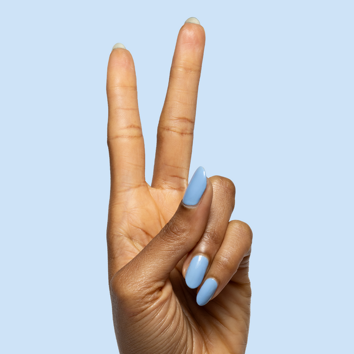 Hand showing peace sign with nails painted in Shades of Seersucker gel polish for a smooth, summery mani look