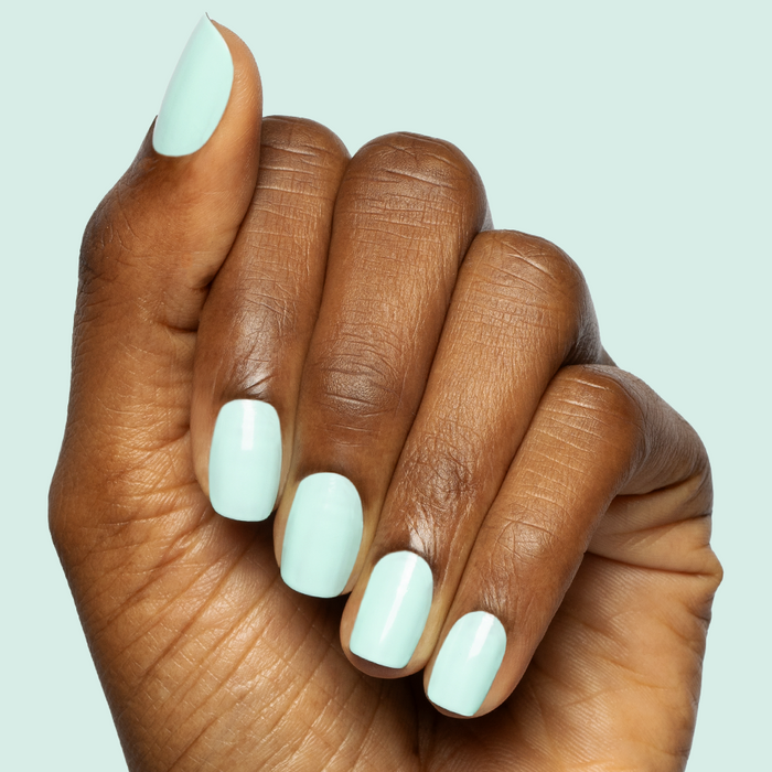 Hand with neatly manicured nails in a true turquoise shade using Slam Dunk gel polish for a fresh at-home mani
