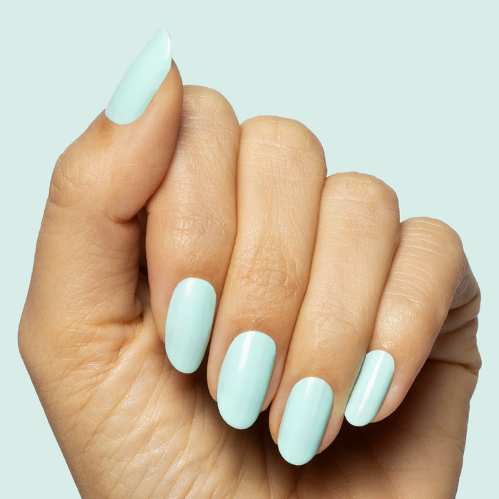 Hand with long nails painted in soft turquoise using Slam Dunk gel polish for a smooth at-home manicure