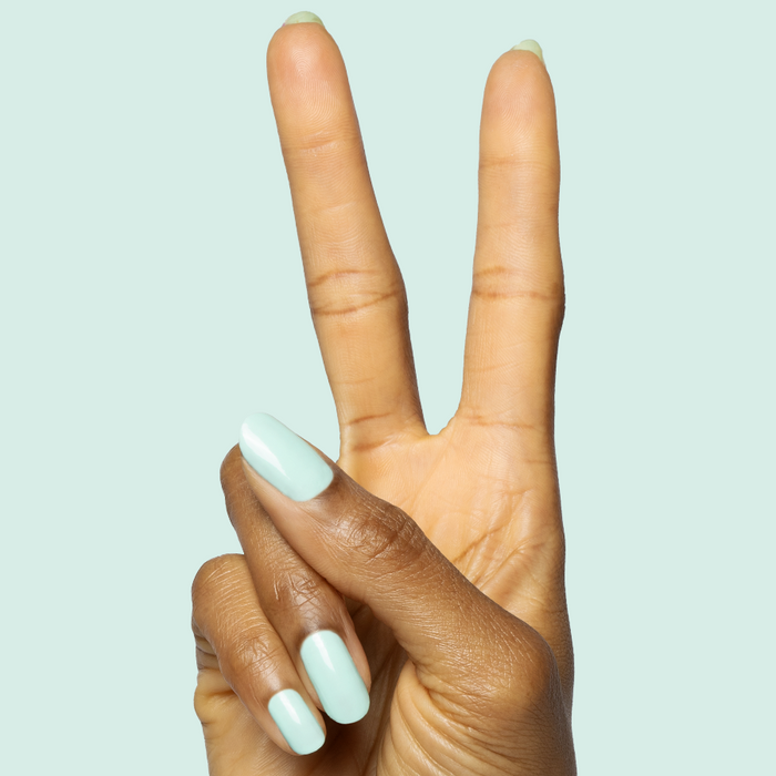 Hand showing peace sign with nails polished in true turquoise shade using Slam Dunk gel polish for at home mani