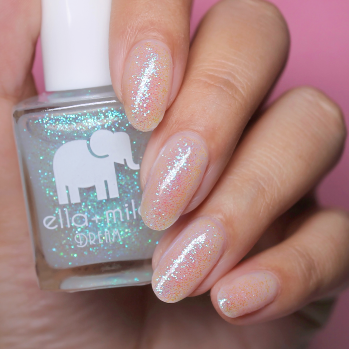 Spin Me Round iridescent shimmer nail polish close-up with the bottle on a pink background