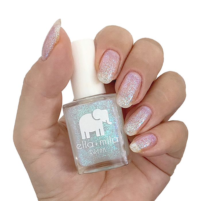Spin Me Round iridescent shimmer nail polish on a medium skin tone, hand holding the bottle
