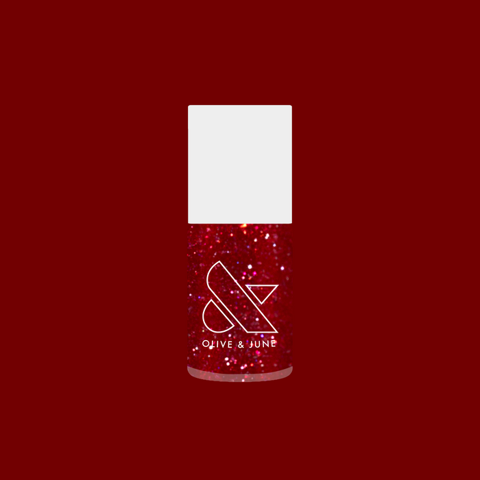 Bottle of Splash of Cran quick dry gel polish in bubbly shimmery pinky-red with glitter on deep red background