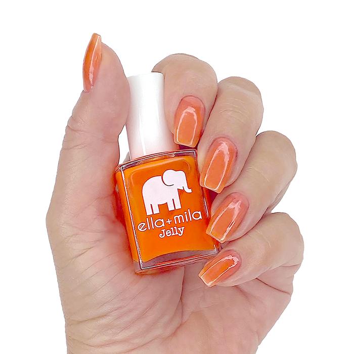 Spread the Love sheer orange jelly nail polish manicure on a light skin tone with the bottle