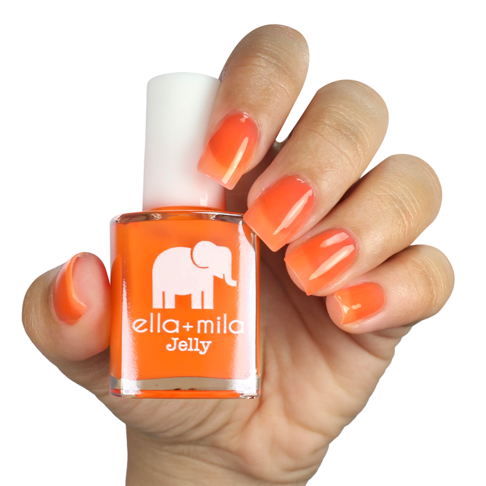 Spread the Love bright orange jelly nail polish on a medium skin tone, hand holding the bottle