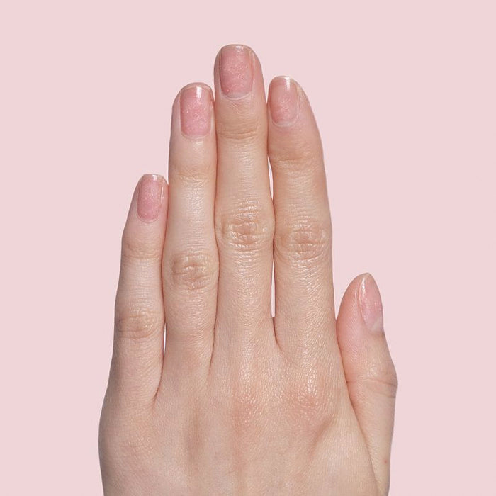 Hand with natural nails showing subtle rose gold shimmer using Starshower polish for a delicate mani by Olive and June