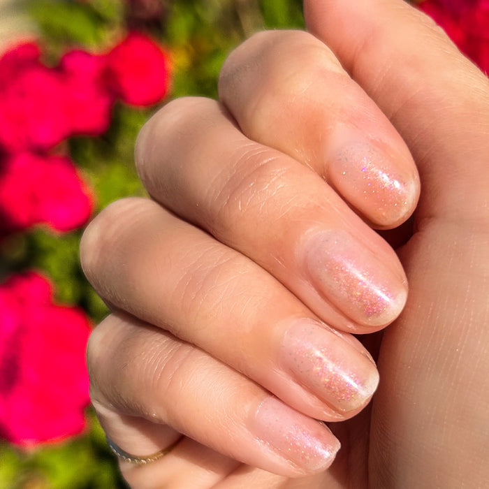 Fingernails with subtle rose gold shimmer from Starshower polish glowing naturally in sunlight for a delicate mani