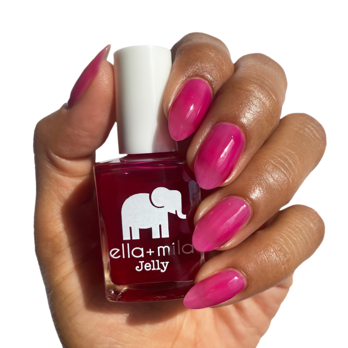 Suga Suga fuchsia jelly nail polish on a deep skin tone, hand holding the bottle