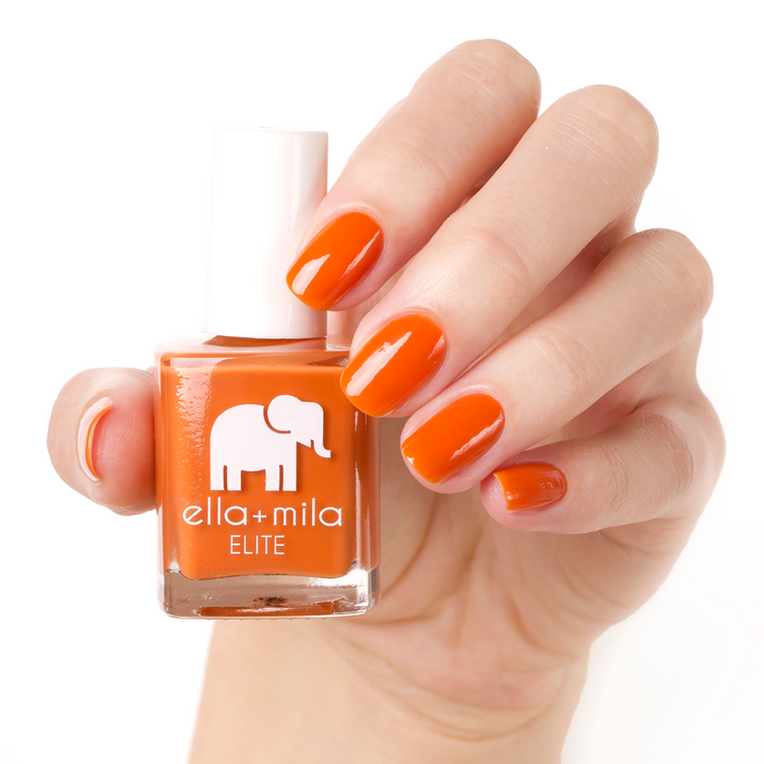 Sunset Escape burnt orange nail polish manicure on a light skin tone with the bottle