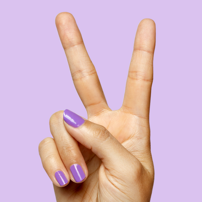 Hand showing peace sign with purple Tennis Skirt nail polish for a bright, quick-dry mani by Olive and June