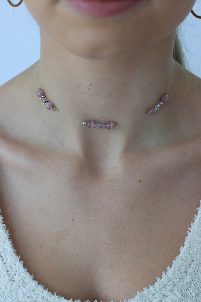 girl poses with a purple beaded choker on
