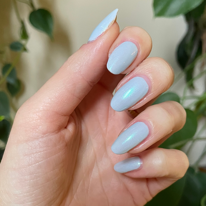 The Mermaid Effect Top Coat adding a subtle iridescent blue-green shimmer to pale blue gel polish for a fresh manicure