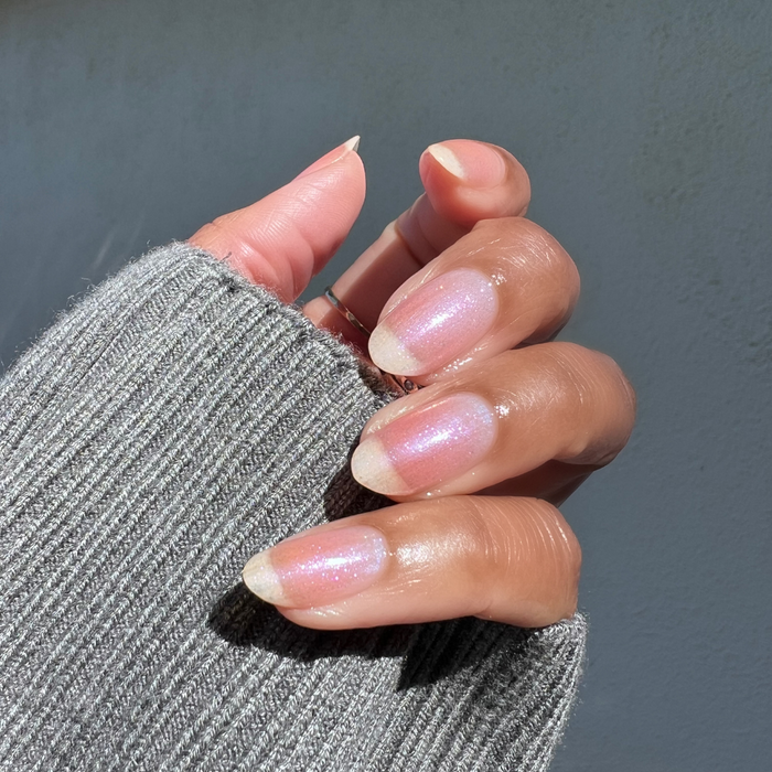 The Sparkle Fairy Effect Top Coat on natural nails with soft pink iridescent shimmer for a radiant manicure look