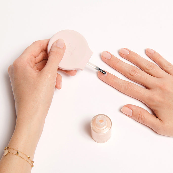 Hand using THE STARTER SET to apply sheer glossy polish for an easy at-home manicure with natural nails