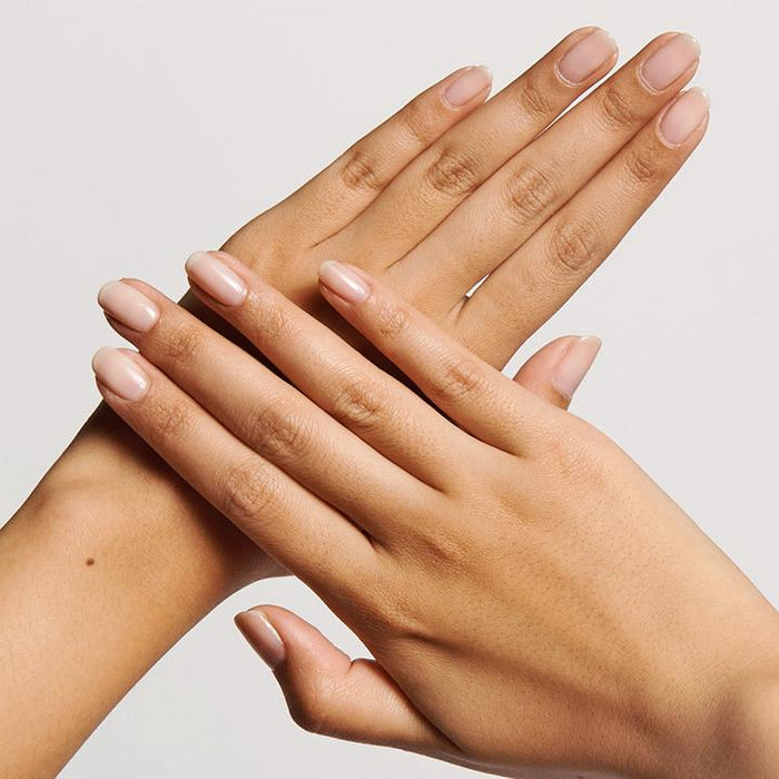 Hands with natural, glossy nails showcasing a smooth mani using THE STARTER SET for an easy at-home manicure