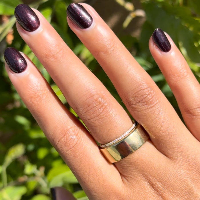 Hand with metallic deep plum nails polished in To Me, You Are Perfect for at-home manicure by Olive and June