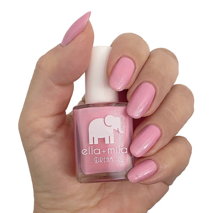 Toes Down Chin Up shimmery pink nail polish manicure on a light skin tone with the bottle