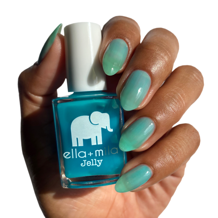 Tooti Fruiti Lover Boy clear water blue jelly nail polish on a deep skin tone, hand holding the bottle