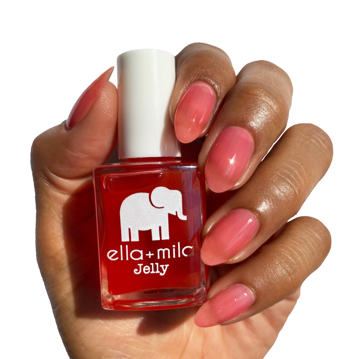 Watermelon Jelly Rancher watermelon jelly nail polish on a medium skin tone, hand holding the bottle