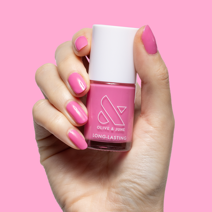 Your Favorite Suit showing hand with glossy peony pink manicure holding matching pink long-lasting gel polish bottle
