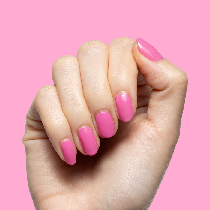 Your Favorite Suit showing hand with bright pink gel polish manicure against matching pink background