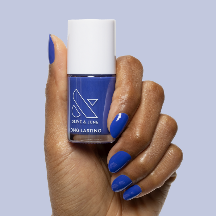 Hand holding Olive and June Your Mani Looks So Good in Those Jeans polish with matching glossy long-lasting manicure