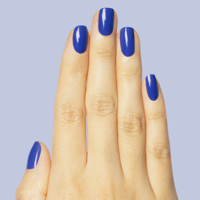 Hand with nails painted in bright denim blue gel polish Your Mani Looks So Good in Those Jeans manicure