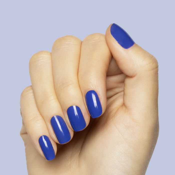 Hand with nails painted in bright denim blue gel polish Your Mani Looks So Good in Those Jeans manicure